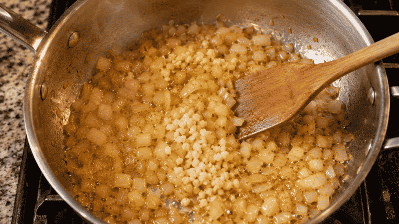 Diced onions and minced garlic sautéing in olive oil in a saucepan — the aromatics base for making homemade pasta sauce from scratch in 20 minutes